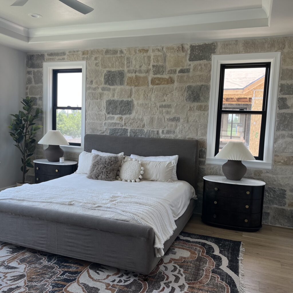 Shows cozy bedroom with new, black frame double hung windows